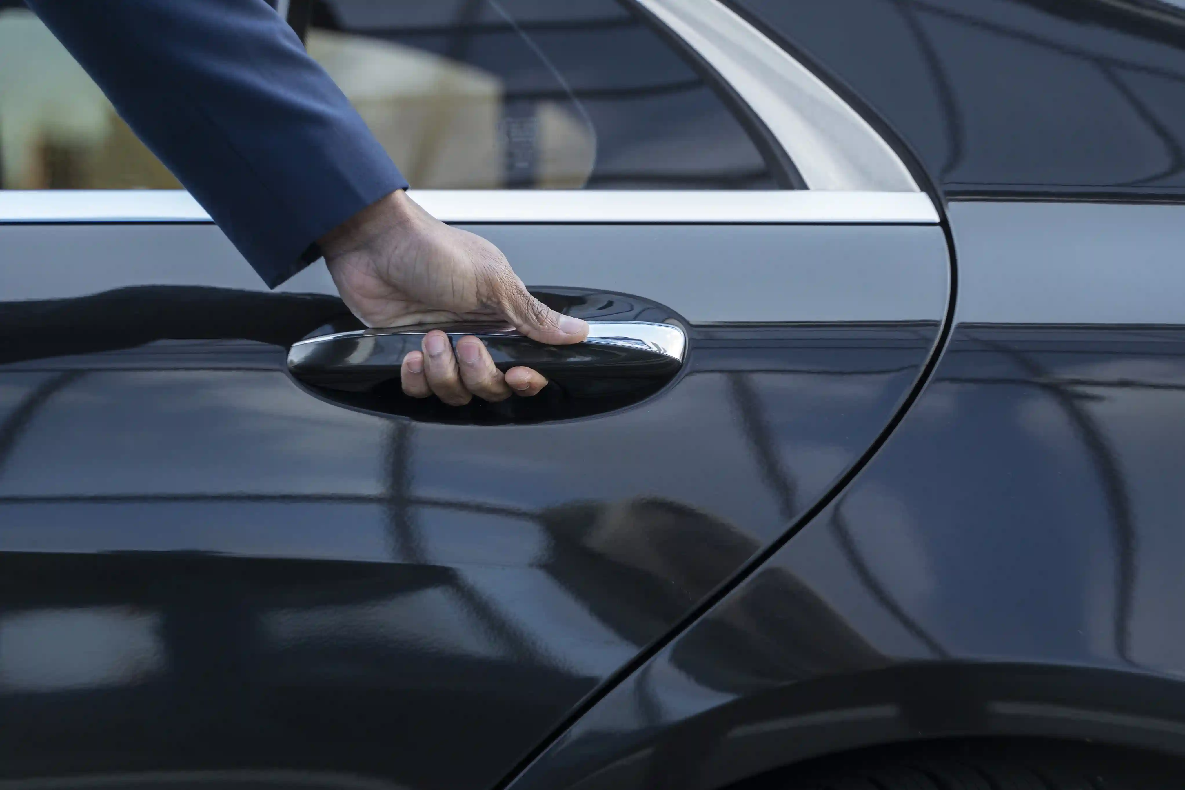 Elegant chauffeur opening the car door 